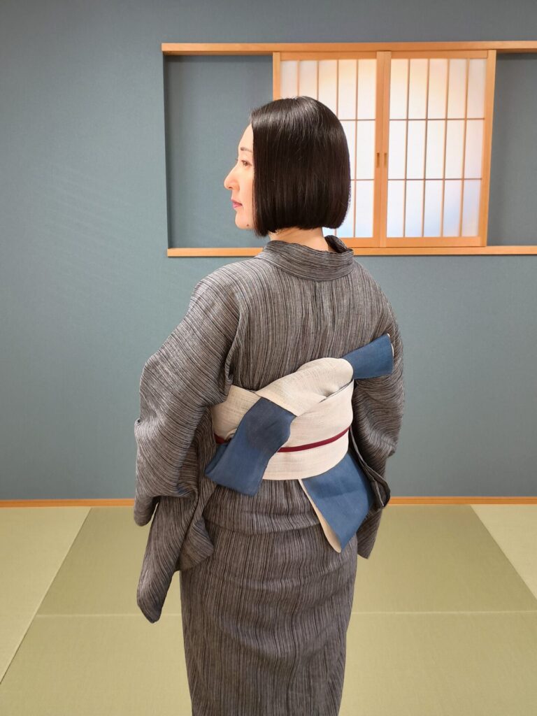 グレーの綿麻に麻の半幅帯を締めた着物の人（9月の着物コーデ）
