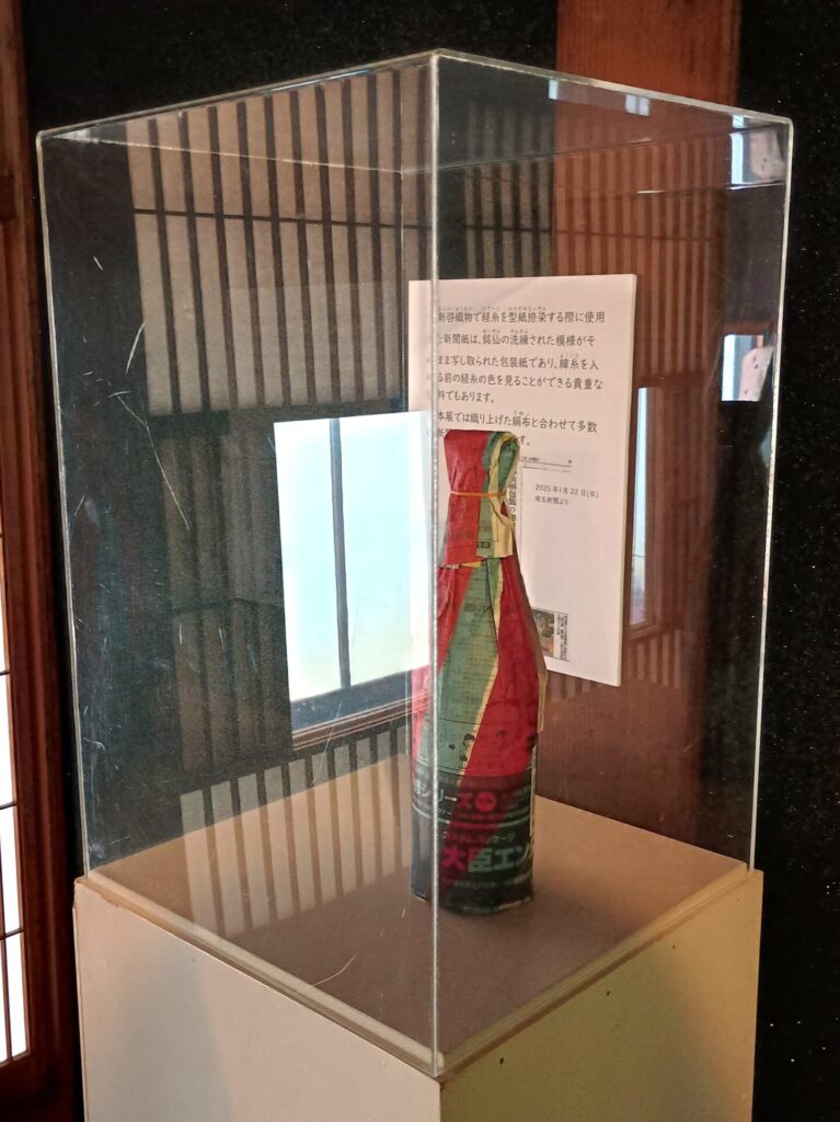 秩父銘仙を捺染した新聞紙で包まれた日本酒