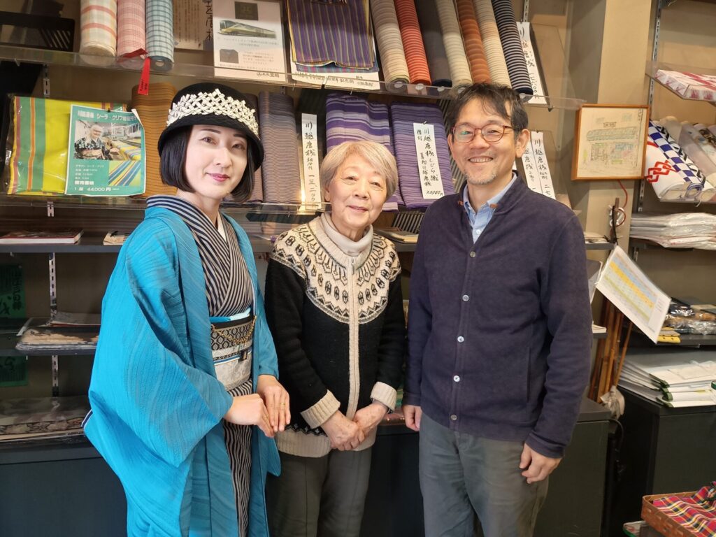 現代物の川越唐桟を着た着物の人と、呉服笠間の店主