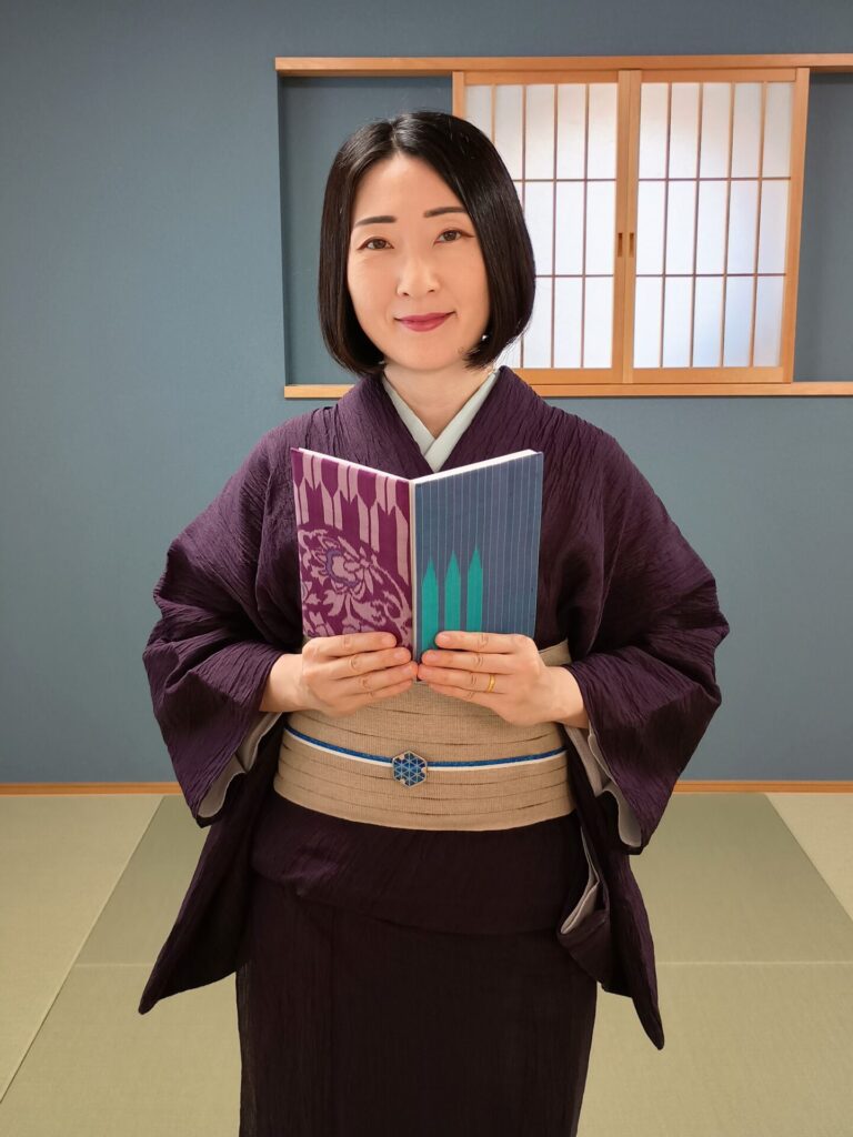 秩父銘仙の御朱印帳を持つ着物の人