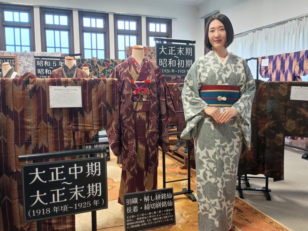 ちちぶ銘仙館「昭和百年メイセン・クロニクル展」の展示前に立つ着物の人