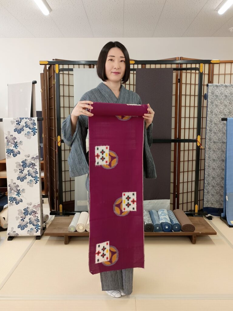 珍絣の伊勢崎銘仙反物を持っている着物の人