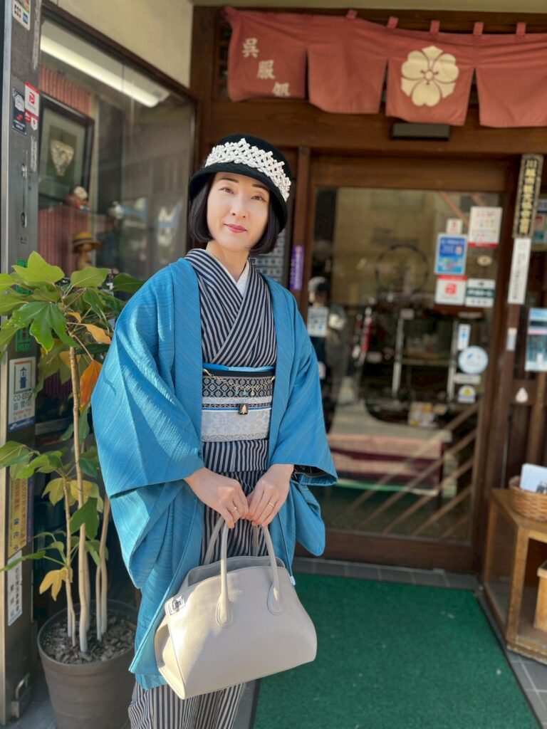 川越唐桟の着物を着て呉服笠間の店舗前に立つ人