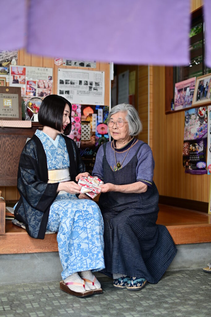 創作足袋 千代の松の店内で商品説明を聞いている、行田足袋をはいている着物の人